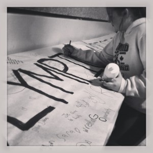 Taylor signing the "Support Olympic Wrestling" banner at the 2013 Renfrew Rumble